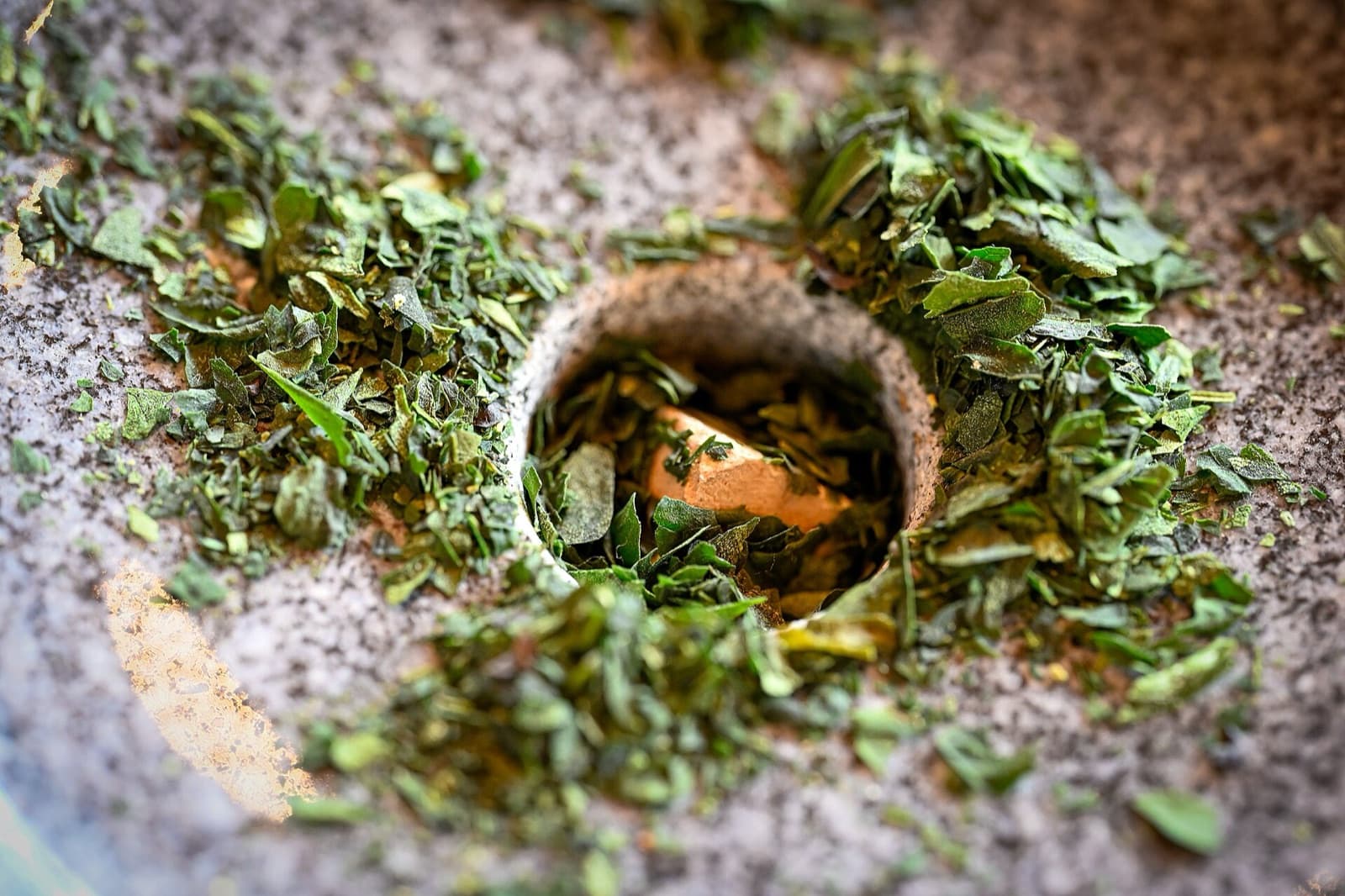 Dried tencha leaves around the opening of a stone mill in Uji, Kyoto